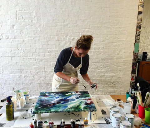A woman creating a beautiful painting using acrylic resin