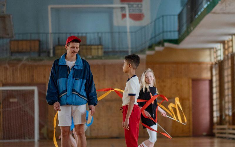physical education teacher coaching students during a school gym class