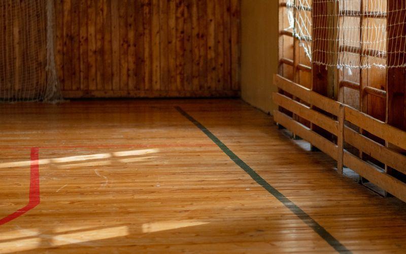 empty school gymnasium with polished wooden floor and painted court lines